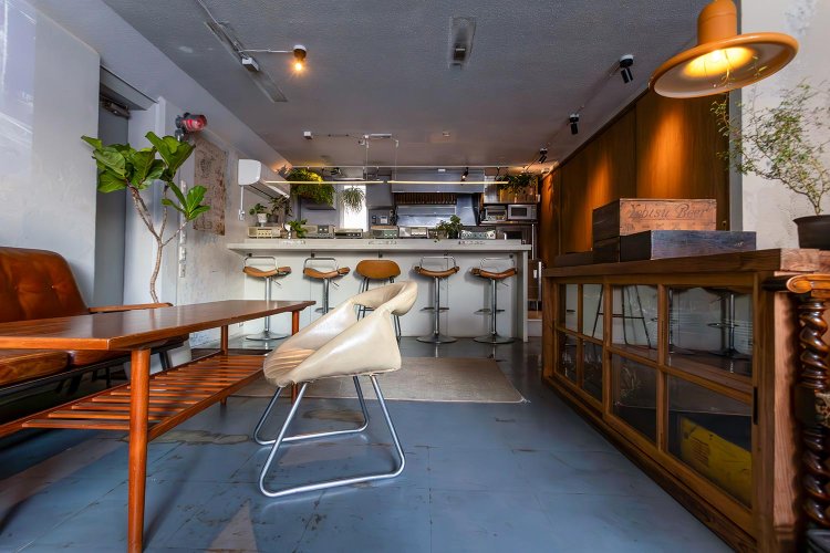 アンティークのテーブルをゆったり配する。まだ明るい15時からの営業。