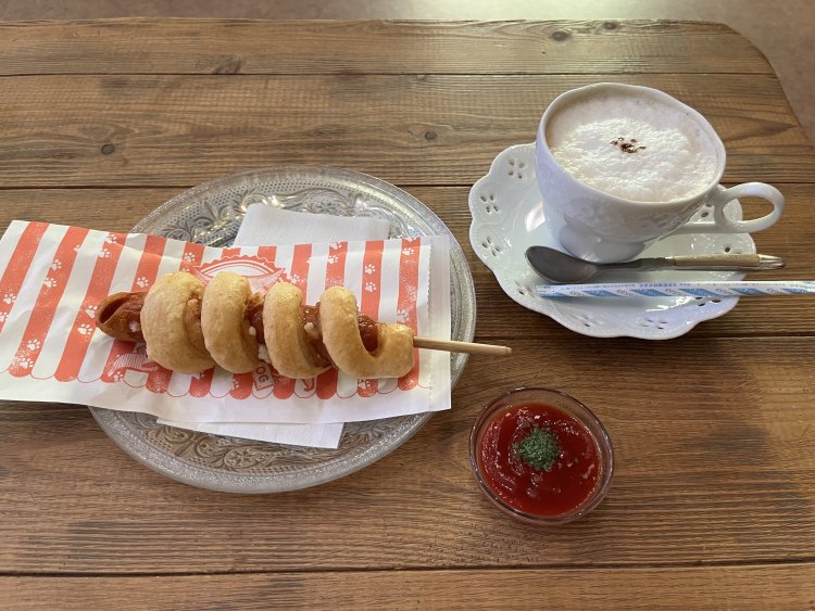 肉球のマークがかわいいふわふわカフェラテ583円と、もちもちドッグ605円。