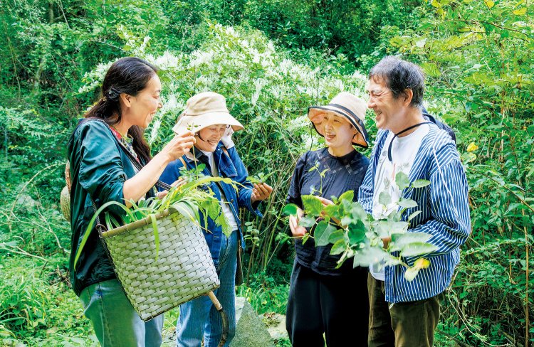 山の持ち主である大野さん（左から2番目）や『ボルベール』の山本眞滋（しんじ） さん・さゆりさん夫妻（右）と野草談議を楽しむ安藤さん。