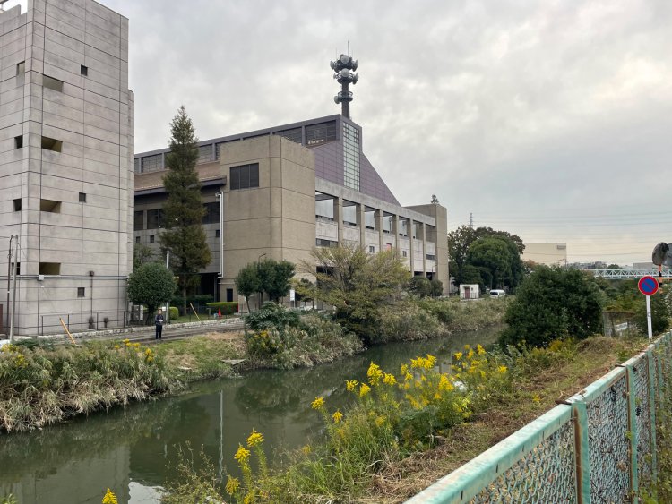 『エネクルスポーツアリーナSOKA』と伝右川。伝右川の足立区側は護岸がコンクリートで固められているが草加市側は自然のまま。