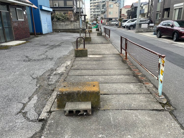 暗渠化された道の上に車止めが置かれている。