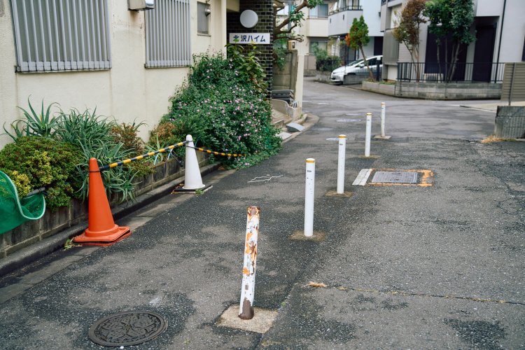 〈A〉暗渠の護り神、車止めが降臨。「I」視点（Imagination 想像・空想）で見れば、川に立てられた杭のよう。