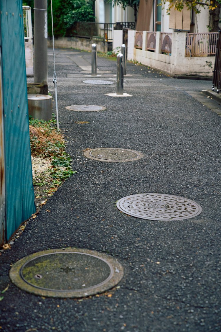 〈C〉高度経済成長期には一気に下水道が普及。並ぶマンホールがかつての川筋をしのばせる。