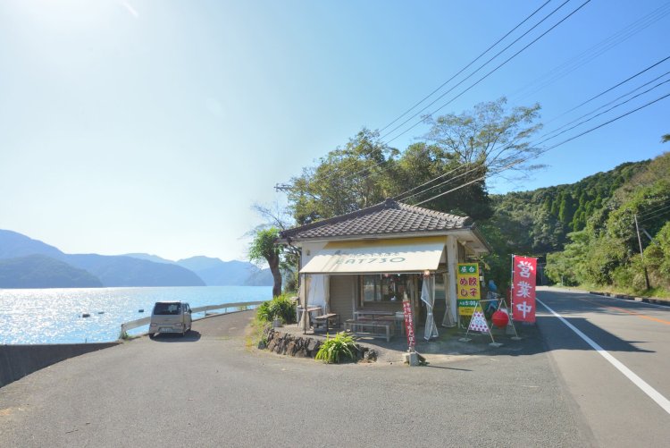 入り組んだリアス海岸で知られる羊角湾に面して立つ。