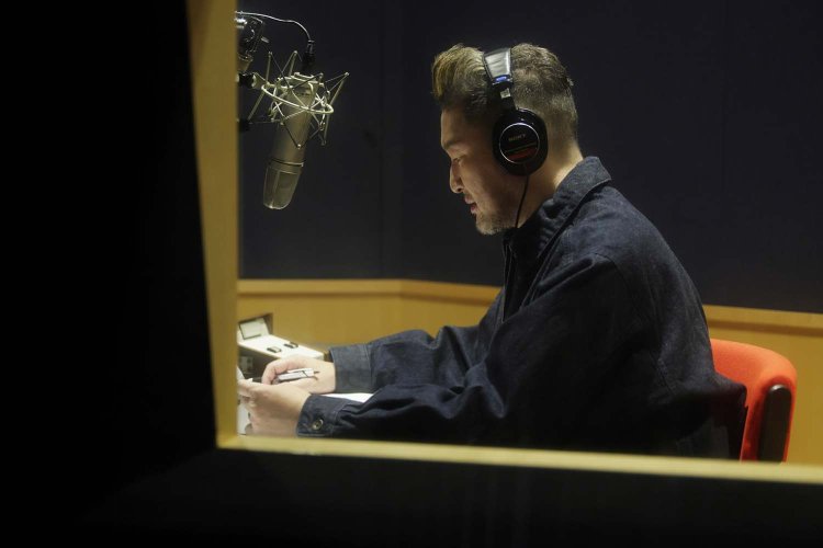 ナレーションブースにて音声収録を行う獅童さん。