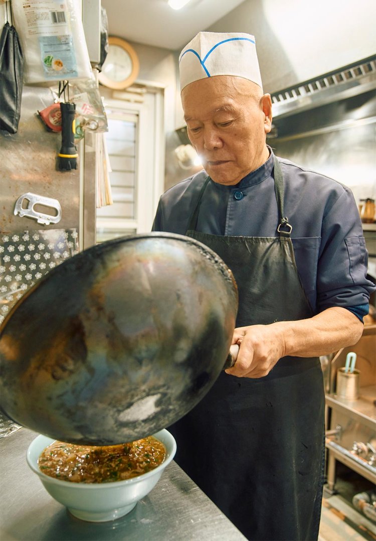 調理場を仕切るのは店主の睦さん。鉄鍋が似合う。