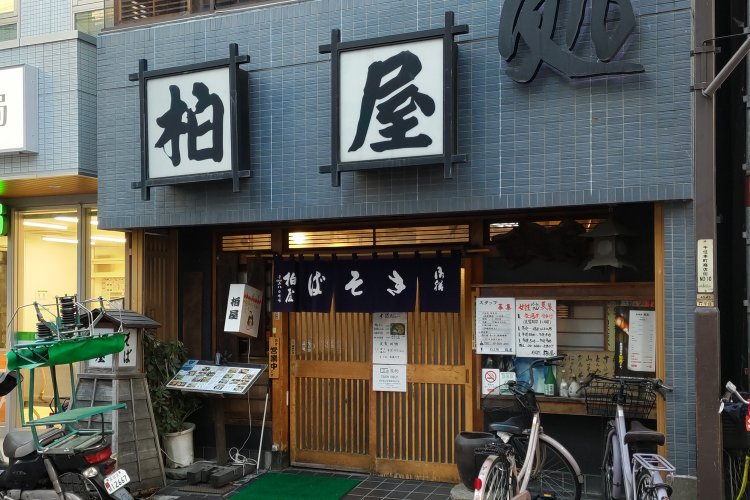 出入り口の上に店名が大きく掲げられている。のれんの文字は、右から左に読む昔ながらの表記。