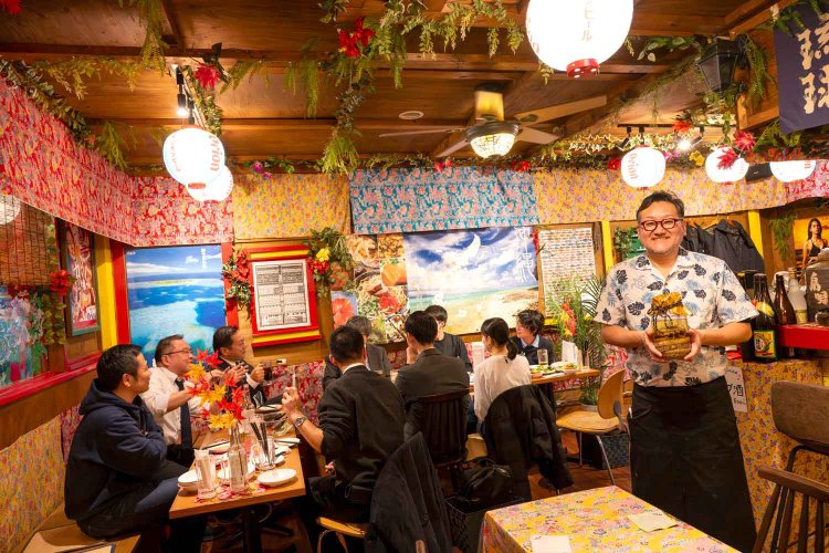 店内は南国ムード満点。店主の手には夫婦ハブ酒500円。