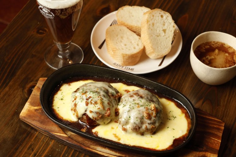 自家製チーズソースがたっぷりかかった、チーズハンバーグW1485円。クラフトビール715円。