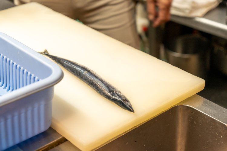 焼かれるのを待つまな板の上のサンマ。