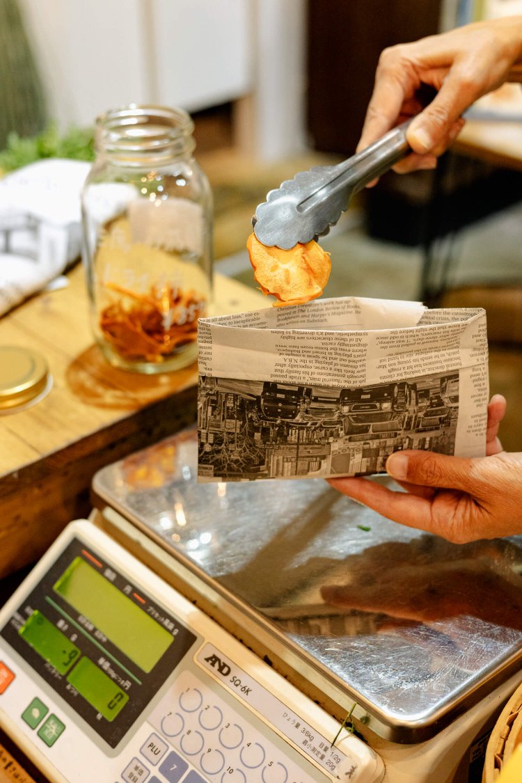 三鷹産ドライ柿。セルフで使う分だけを新聞紙の袋に入れるスタイル。