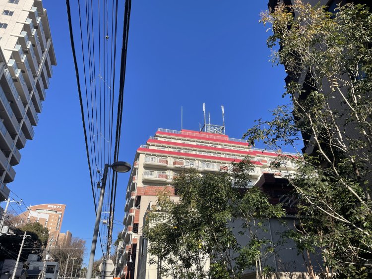 街道沿いを歩いていると、赤とクリーム色の配色がおしゃれなマンションが目に止まった。