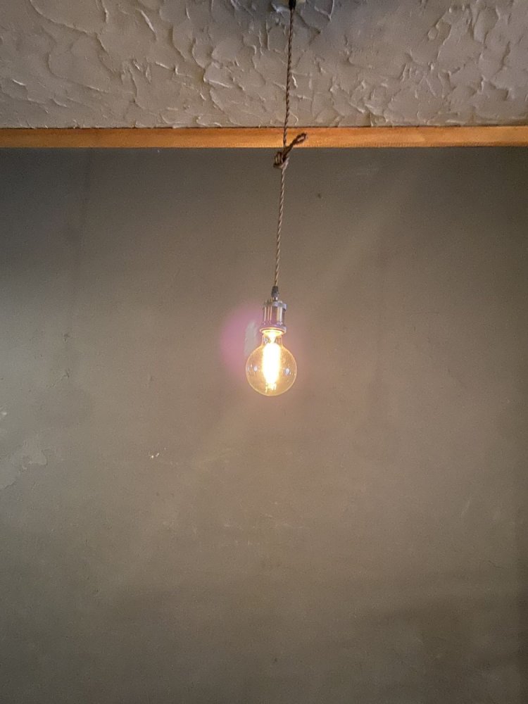 電球のフィラメントのほのかな光が照らす、明るいグレーの壁が店内の色調。