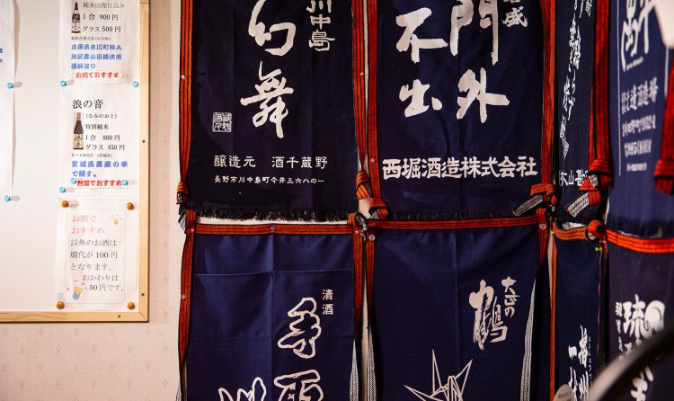 店内の壁には酒蔵の前掛けがいくつも。