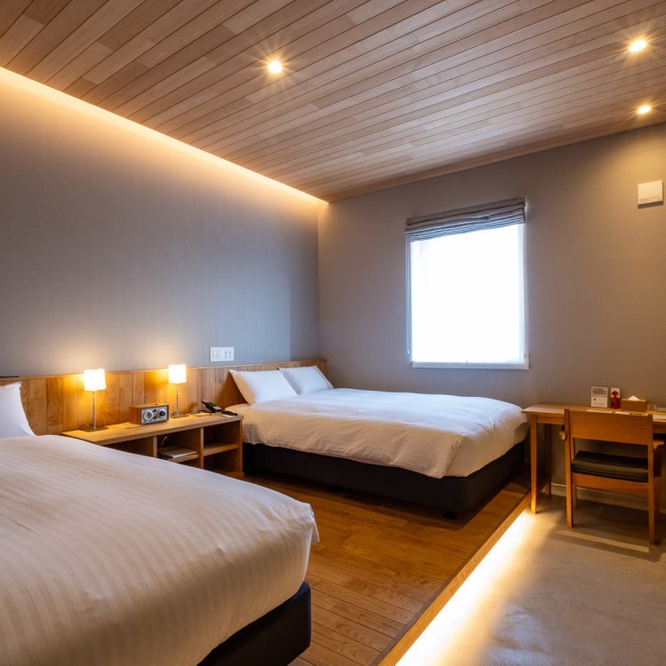 使い勝手のよい土間や温もりある無垢材の床、職人が手がけた家具が目を引く客室（写真はエグゼクティブツインB）。