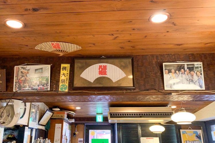 店内には、誕生八幡神社のグッズやお祭りで撮った写真も飾られている。