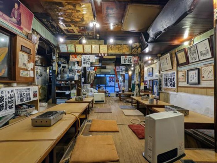 壁、天井のあらゆる場所にポスターや額縁、色紙などが張りめぐらされている。