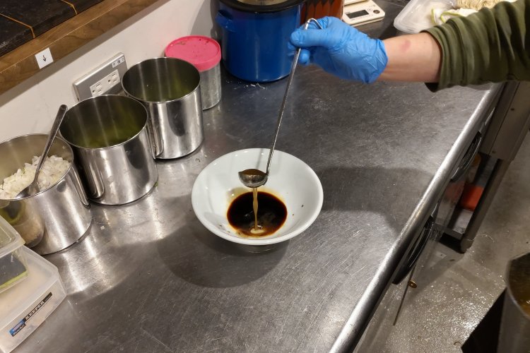 味の決め手となる香味油をプラス。その後、出汁を加えて透き通ったスープに仕上げる。