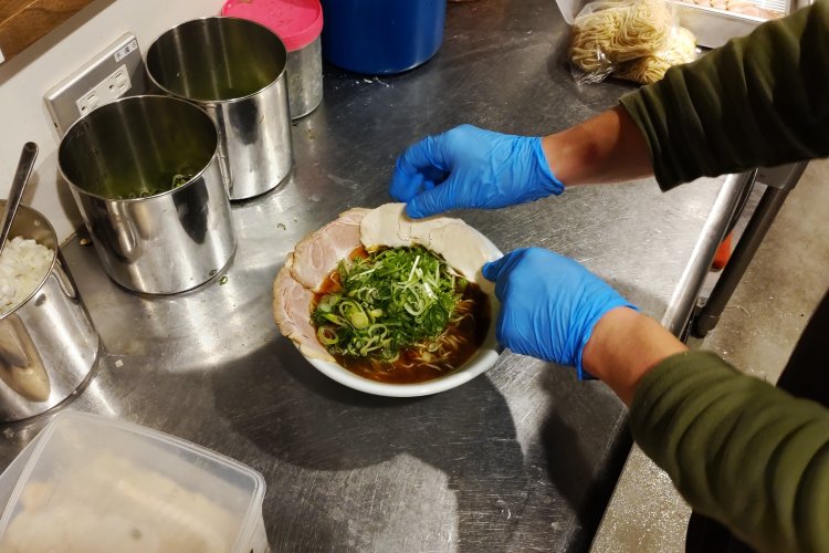 2種類のチャーシューやタマネギ、水菜、ネギのほか、餅、味玉、海苔を盛り付ければ完成。