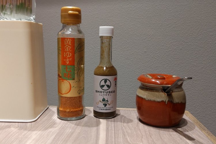 卓上の各種調味料を加えるのもおすすめ。写真左から黄金ゆず七味、しょうゆすこ、おろしニンニク。