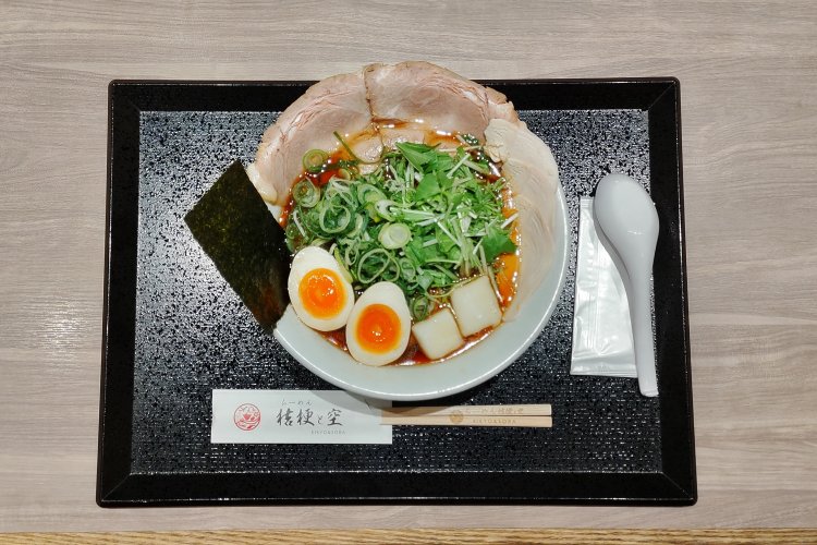 淡麗醤油味玉らーめん。水菜やネギを囲むように配置された各種具材が、多彩な味わいや食感を生む。