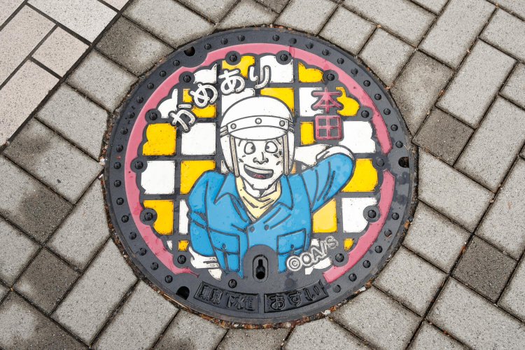 こち亀デザインマンホールは6種類。本田マンホールは北口すぐ。
