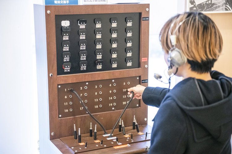 1階ロビーでは、磁石式電話機での通話や手動交換機で交換手体験もできる。
