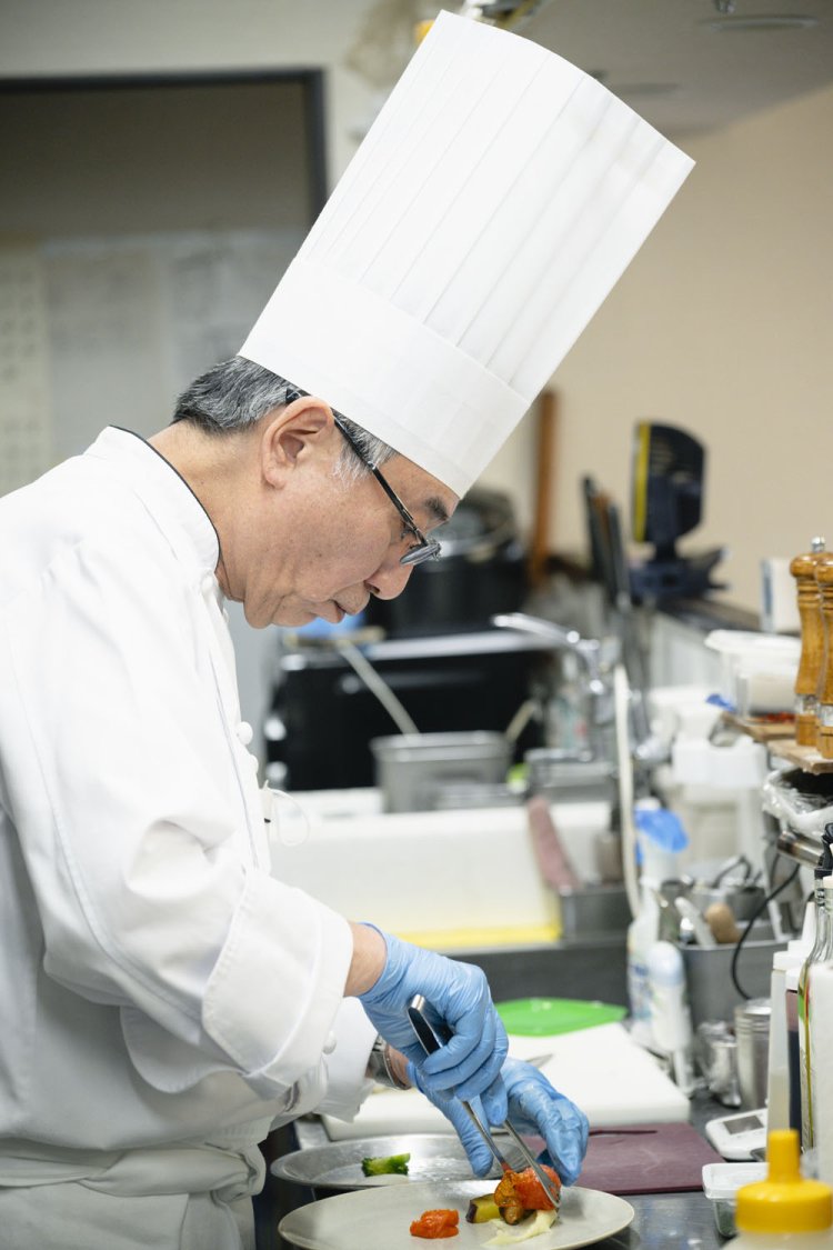 メインを盛り付ける鈴木さん。