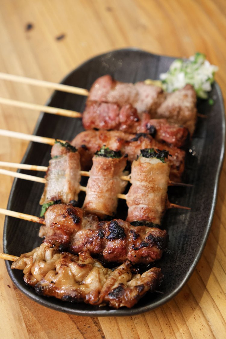 手前から秘密の仕込み方法でやわらかく仕上げたシロ、チレ各150円、肉巻パクチー250円、プリサク食感のオッパイ200円など。コクのあるタレ、味噌、塩から味付けを選べる。