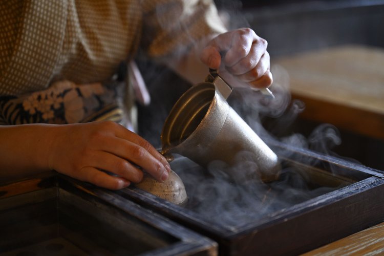 寒い日は2台の燗銅壺（かんどうこ）の前に座りたい。湯煎の温度は65℃と85℃に設定。