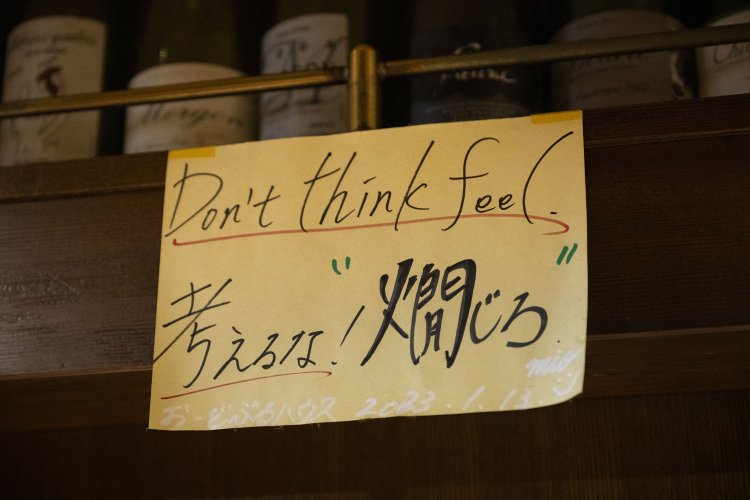 カウンターの上に掲げられたメッセージ。 今では、ワインより燗酒を頼む客の方が多くなったそう。