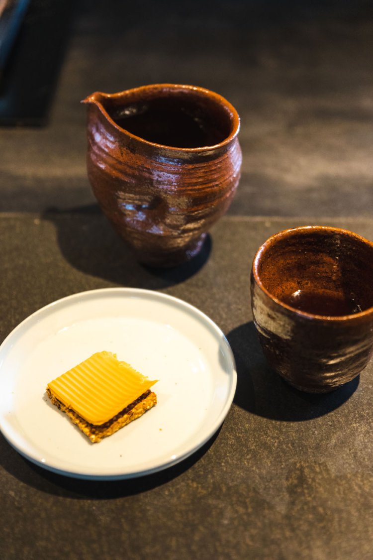 「Kokekaffe（クーケカッフェ）」1500円。抽出後にペーパーフィルターを通して完成。夕日焼のカップとキネッキブラ・ブラウンチーズをのせたクラッカーとともに。