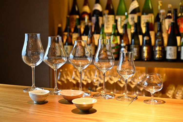 旨味の豊富な熟成酒を提供する酒器も多彩。常温は、ガラス製のオリジナルグラスで提供。リムの反り返りやストロークがポイント。燗酒も酒質により、材質と形、厚みの異なる平盃を使い分ける。