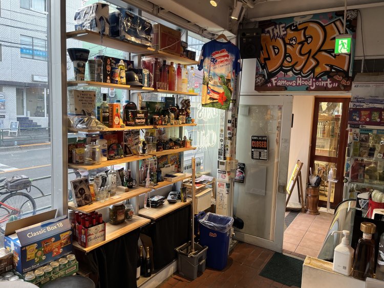 棚いっぱいに収められた雑貨はアメリカから取り寄せたもの。フィギュアやタバスコ、洗剤にコンドームまで並ぶ。