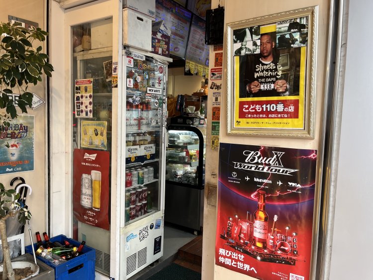 箱いっぱいのお酒の空き瓶があるかと思えば、ドアにはいかついお兄さんと共に「こども110番の店」の文言を掲げるポスターもある。