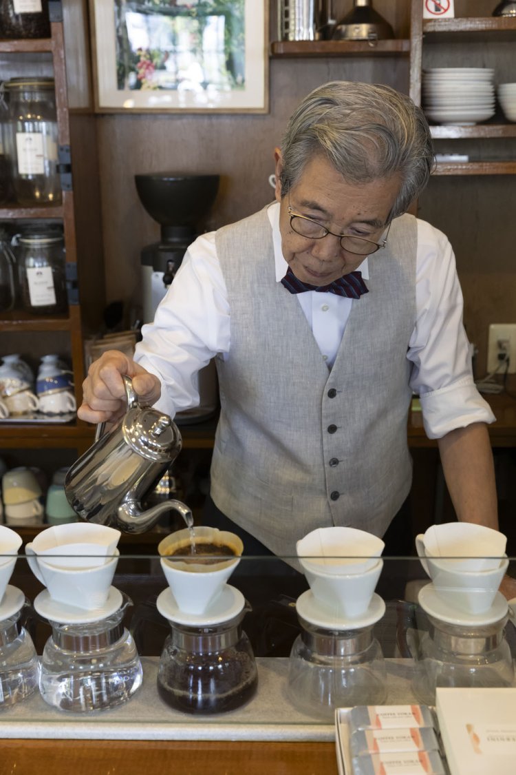 蝶ネクタイ姿で抽出する俊雄さん。多くの人をコーヒーの虜にしてきた。