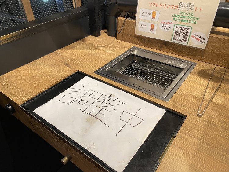 焼肉店のロースターに添えられた、緊急度の高い「調整中」。