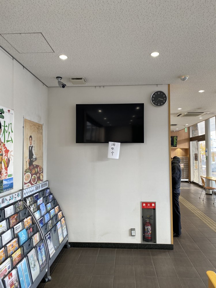 バスターミナルの待合室にて、無言のモニターに垂れ下がる「調整中」。