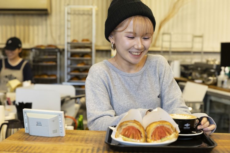 スタッフが手際よくラテを淹れ、サンドイッチを切ってくれた。笑顔の応対がうれしい。