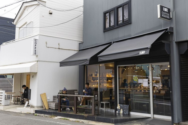 モノトーンで揃えたシックな外観。テラス席もある。奥の白い建物が『CORNER 27』。