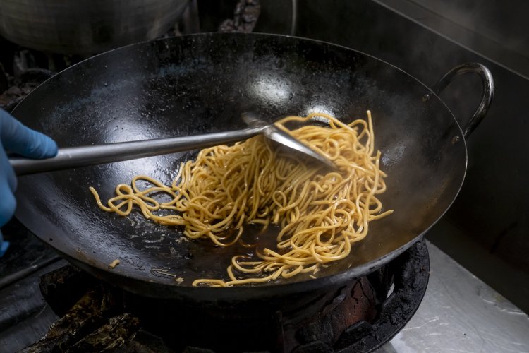 蒸し麺をそのまま炒めるとボソボソになるため、『うしお』では茹でてから炒める。