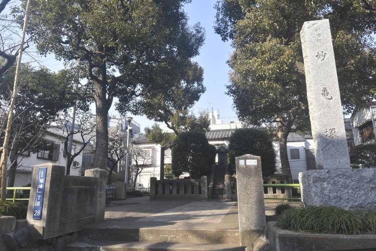 小さな公園にある妙亀塚。都の史跡に指定されている。