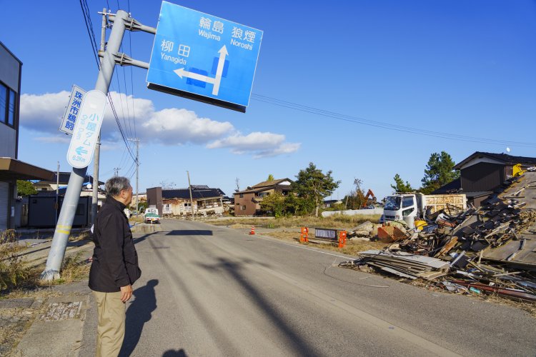 全壊した家屋の解体が進む宝立町。 標識も大きく傾いたままだ。