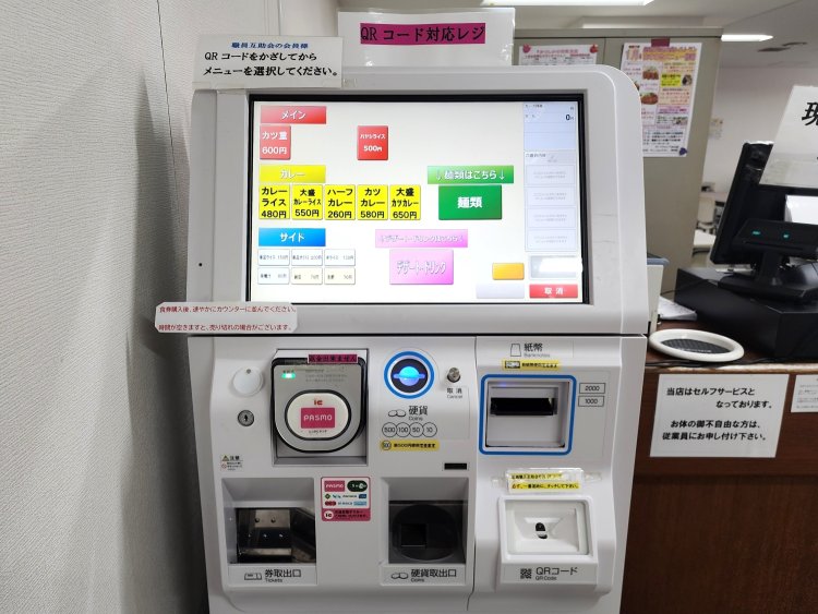 廊下の券売機は昔ながらのボタン式。店内の券売機はタッチパネル式で交通系電子マネーも使用できる。