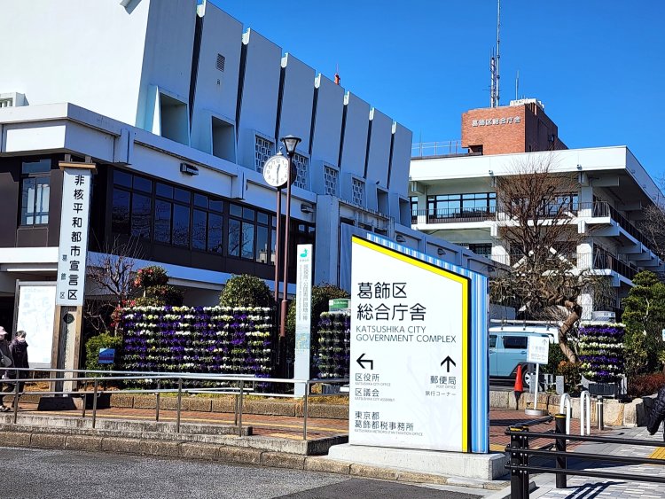 この案内板を左に曲がると区役所正面に出る。食堂は奥に見えるレンガ色の建物の1階。