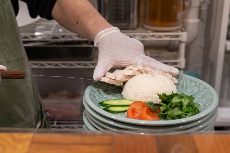 カウンターの中で手際よく盛り付けられていくカオマンガイ。