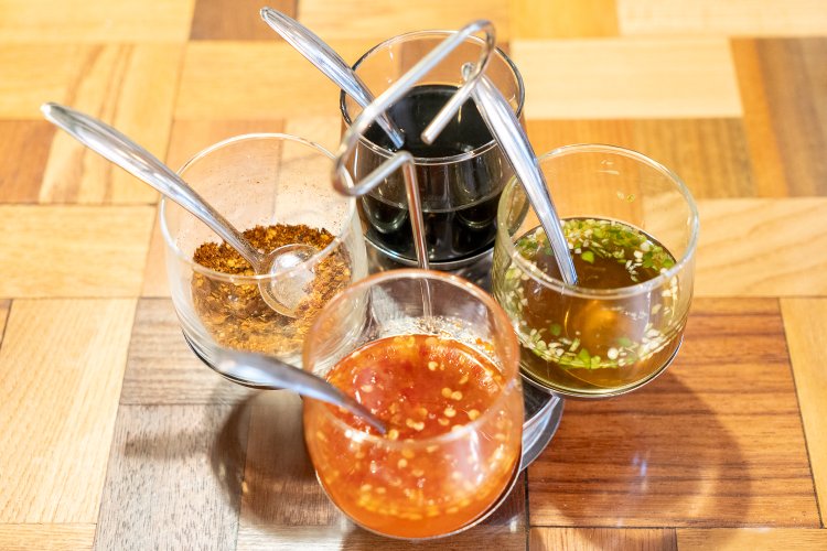 上から時計回りにブラックスイートソース、青トウ酢、スイートチリソース、赤唐辛子粉末。