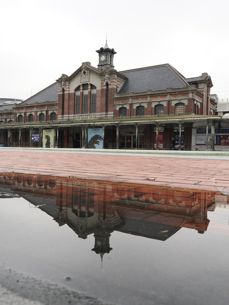 水たまりに写りこむ駅舎の姿が美しい。