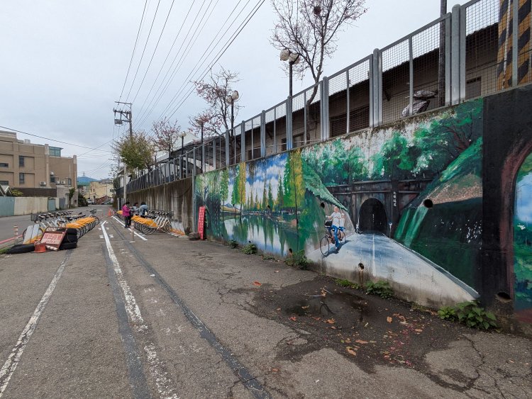 后里（Houli）駅には貸自転車店もあるが、駅前にはYouBikeがある。駅の壁面には旧線跡の見どころが描かれていた。
