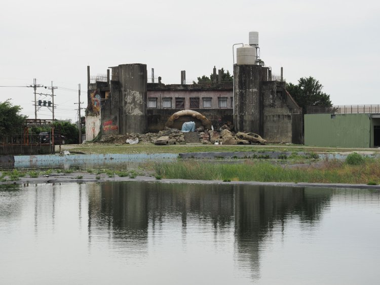 プール更衣室を兼ねていたコンクリート建物。散策しようとしたら映画ロケの最中だったようで、立ち入りを許されなかった。外観は廃自動車が積み重ねられ、ちょっと戦場らしい雰囲気。半円状のオブジェもロケセットらしい。